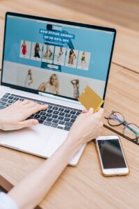 a person using laptop while holding a credit card